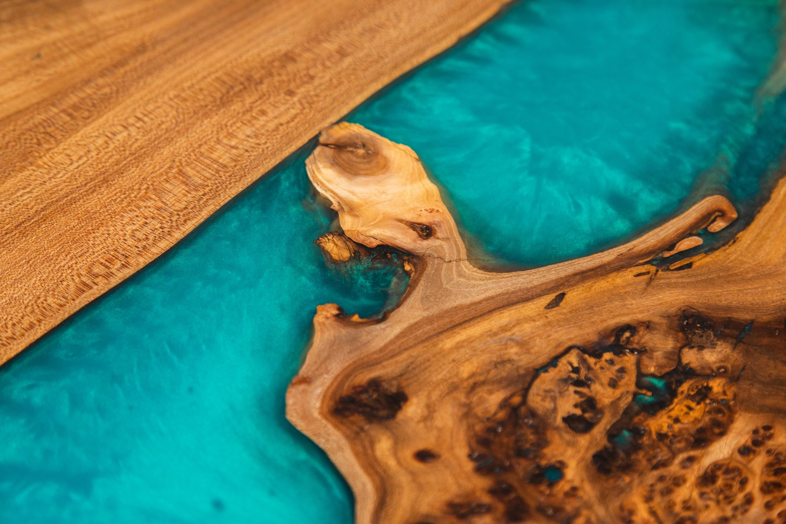 Texture of handmade wooden river table with decorative epoxy blue resin